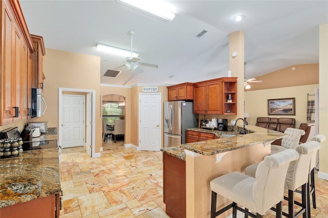 12495 SW 66th St, Ocala, FL 34481 - kitchen featuring ceiling fan, appliances with stainless steel finishes, a sink, brown cabinets, and lofted ceiling