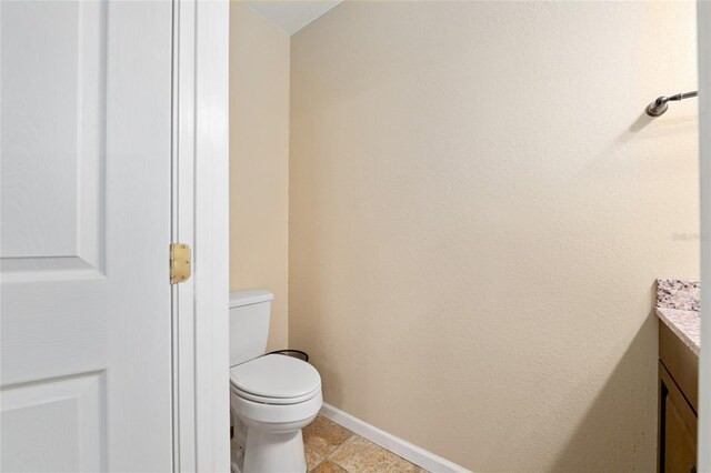 12495 SW 66th St, Ocala, FL 34481 - bathroom featuring vanity, toilet, baseboards, and tile patterned flooring
