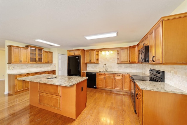8745 SW 92nd St Unit B, Ocala, FL 34481 - kitchen with black appliances, a sink, light wood-style floors, and tasteful backsplash