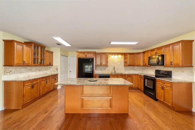 8745 SW 92nd St Unit B, Ocala, FL 34481 - kitchen with black appliances, a sink, brown cabinets, and decorative backsplash