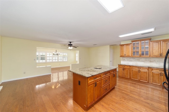 8745 SW 92nd St Unit B, Ocala, FL 34481 - kitchen featuring a center island, brown cabinetry, tasteful backsplash, light wood-style floors, and open floor plan