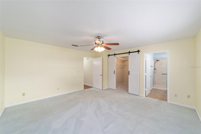 8745 SW 92nd St Unit B, Ocala, FL 34481 - unfurnished bedroom featuring a barn door, light carpet, a spacious closet, baseboards, and ensuite bathroom