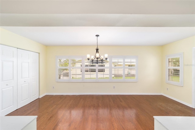 8745 SW 92nd St Unit B, Ocala, FL 34481 - unfurnished dining area with a chandelier, wood finished floors, and baseboards