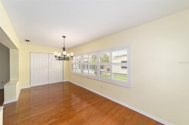 8745 SW 92nd St Unit B, Ocala, FL 34481 - unfurnished dining area with a chandelier, baseboards, and wood finished floors