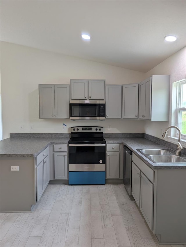 2825 SW 147th Ct, Ocala, FL 34481 - kitchen featuring stainless steel appliances, a sink, gray cabinets, lofted ceiling, and light wood finished floors