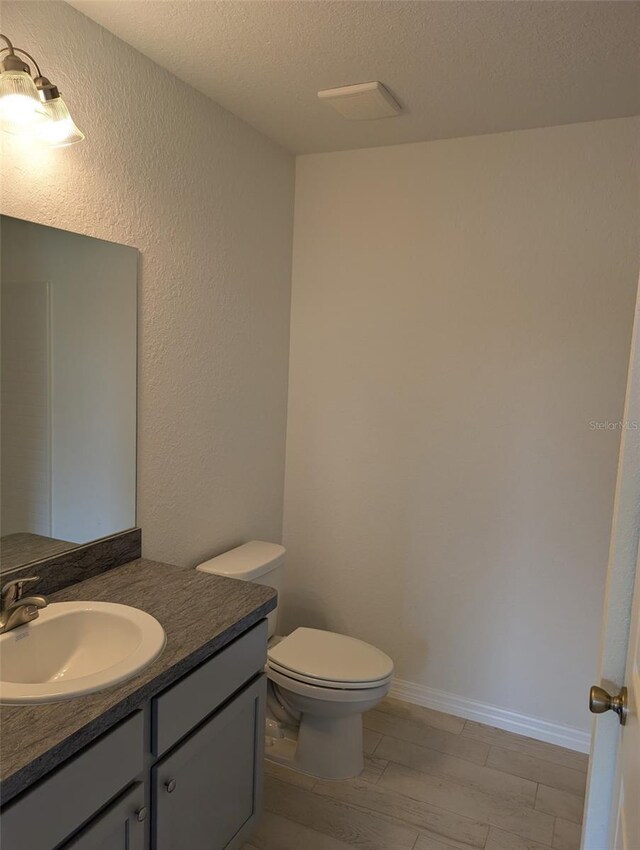 2825 SW 147th Ct, Ocala, FL 34481 - bathroom featuring vanity, a textured ceiling, toilet, and wood finished floors