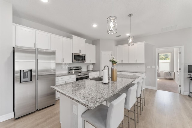 14055 SW 30th Terrace Rd, Ocala, FL 34473 - kitchen featuring appliances with stainless steel finishes, a sink, recessed lighting, light wood finished floors, and white cabinets