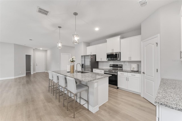 14055 SW 30th Terrace Rd, Ocala, FL 34473 - kitchen featuring stainless steel appliances, light wood finished floors, a breakfast bar, a sink, and recessed lighting