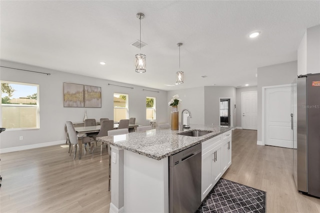 14055 SW 30th Terrace Rd, Ocala, FL 34473 - kitchen with stainless steel appliances, a sink, light wood-style floors, white cabinets, and recessed lighting