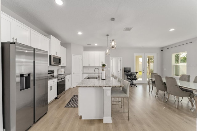 14055 SW 30th Terrace Rd, Ocala, FL 34473 - kitchen featuring stainless steel appliances, a sink, a kitchen bar, white cabinetry, and recessed lighting