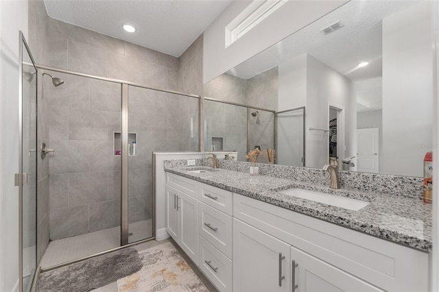 14055 SW 30th Terrace Rd, Ocala, FL 34473 - full bathroom with double vanity, a stall shower, a spacious closet, and a textured ceiling