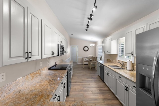 14481 SW 112th Cir, Dunnellon, FL 34432 - kitchen featuring appliances with stainless steel finishes, a sink, wood finished floors, white cabinets, and lofted ceiling