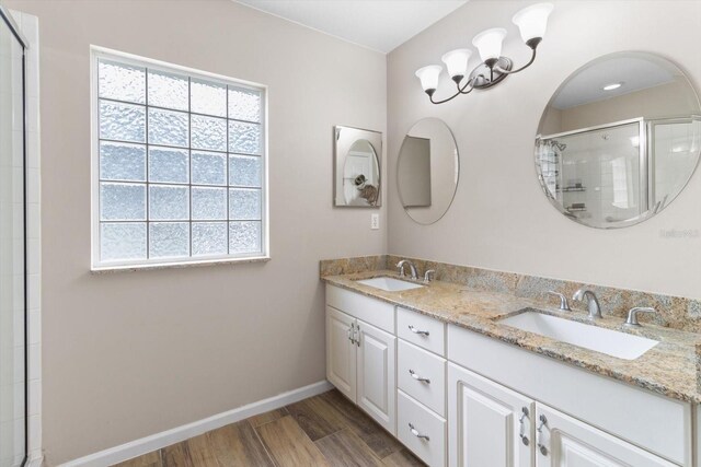 14481 SW 112th Cir, Dunnellon, FL 34432 - bathroom featuring double vanity, wood finished floors, baseboards, and a tile shower