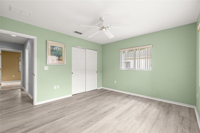 9891 SE 138th Loop, Summerfield, FL 34491 - unfurnished bedroom with light wood finished floors, a closet, baseboards, and ceiling fan
