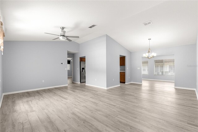 9891 SE 138th Loop, Summerfield, FL 34491 - unfurnished living room featuring a chandelier, lofted ceiling, a ceiling fan, light wood-style floors, and baseboards