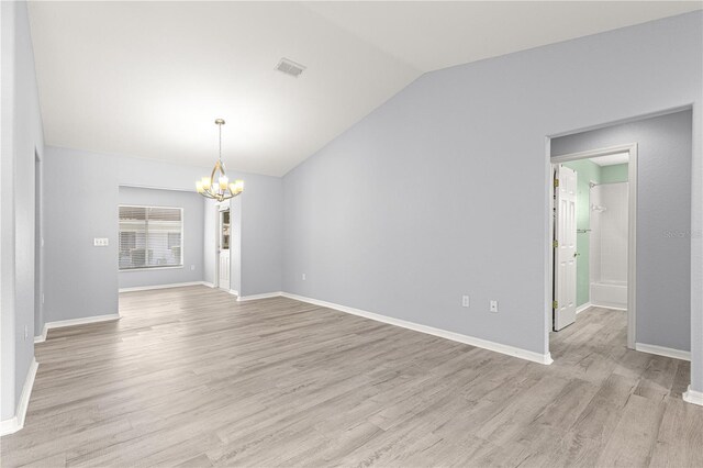9891 SE 138th Loop, Summerfield, FL 34491 - spare room featuring a chandelier, lofted ceiling, light wood finished floors, and baseboards