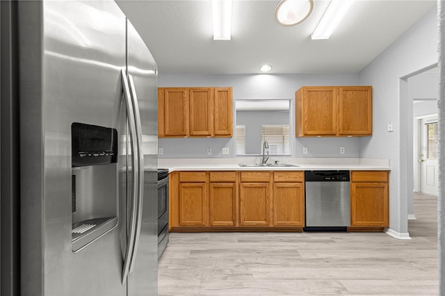 9891 SE 138th Loop, Summerfield, FL 34491 - kitchen with stainless steel appliances, a sink, light countertops, and light wood-style floors