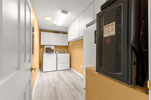 9891 SE 138th Loop, Summerfield, FL 34491 - washroom featuring light wood-style floors, cabinet space, washer and clothes dryer, and baseboards