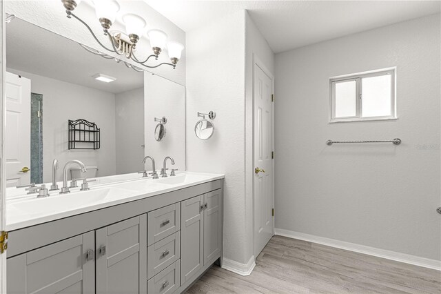 9891 SE 138th Loop, Summerfield, FL 34491 - full bath featuring wood finished floors, double vanity, baseboards, and a chandelier