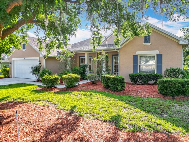 16 Ryewood Cir, Homosassa, FL 34446 - view of front of house with stucco siding, an attached garage, driveway, and a front lawn