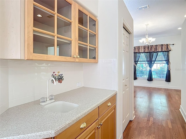16 Ryewood Cir, Homosassa, FL 34446 - kitchen featuring a chandelier, a sink, tasteful backsplash, glass insert cabinets, and dark wood-type flooring