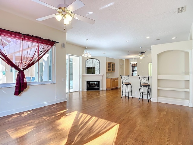 16 Ryewood Cir, Homosassa, FL 34446 - living area featuring ceiling fan, wood finished floors, built in features, a textured ceiling, and baseboards