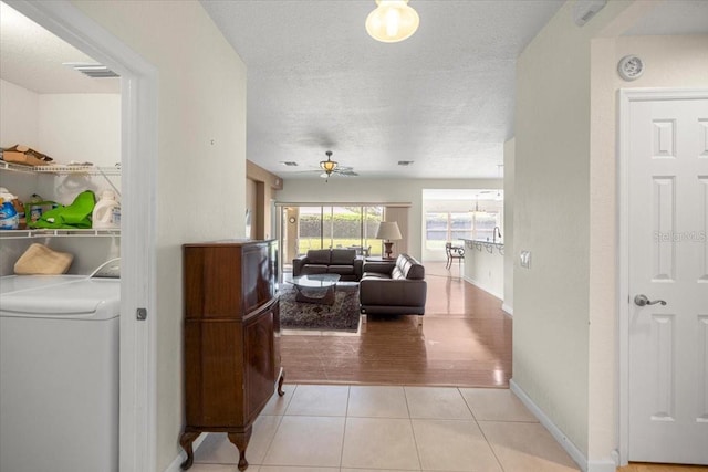 4225 SW 57th Ave, Ocala, FL 34474 - corridor with washer / clothes dryer, light tile patterned floors, a textured ceiling, and baseboards