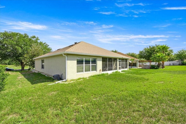 4225 SW 57th Ave, Ocala, FL 34474 - back of property with stucco siding, a sunroom, and a yard