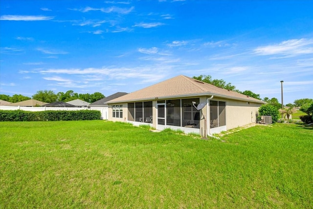 4225 SW 57th Ave, Ocala, FL 34474 - rear view of property featuring a sunroom, central AC unit, a lawn, and stucco siding