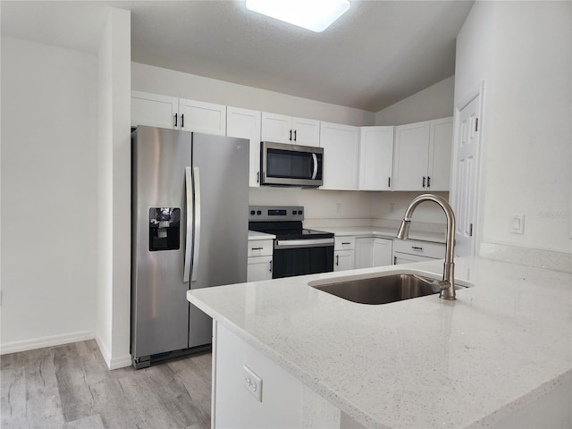 541 56th Ct, Ocala, FL 34482 - kitchen with stainless steel appliances, a sink, a peninsula, white cabinets, and light stone countertops