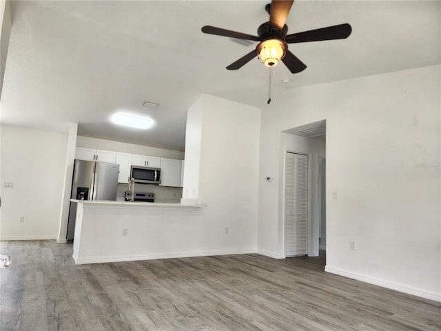 541 56th Ct, Ocala, FL 34482 - unfurnished living room with light wood-type flooring, ceiling fan, lofted ceiling, and baseboards