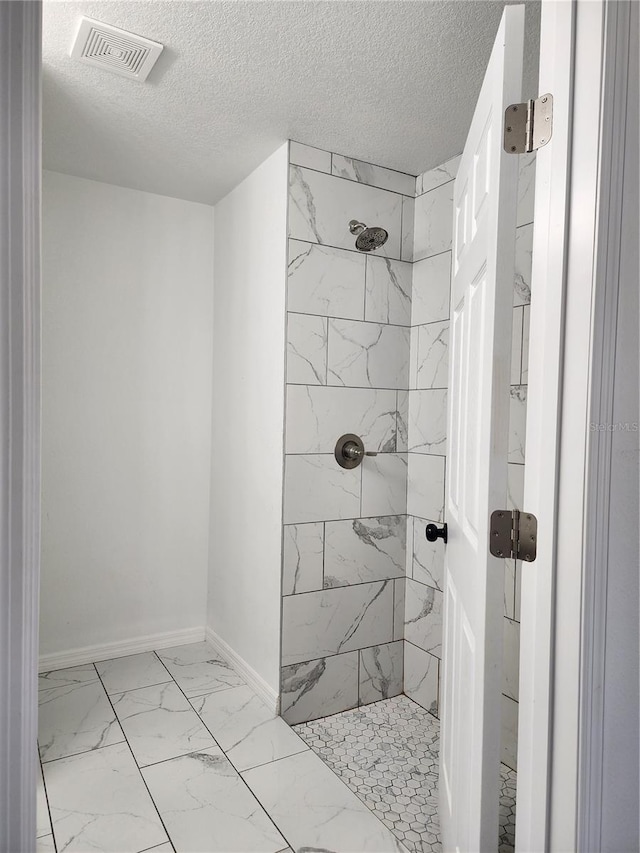 541 56th Ct, Ocala, FL 34482 - full bathroom with marble look tile flooring, tiled shower, a textured ceiling, and baseboards