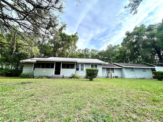 2409 NW 7th St, Ocala, FL 34475 - view of front of home featuring entry steps, a front lawn, metal roof, and a sunroom