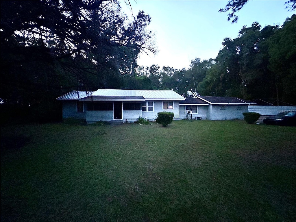 2409 NW 7th St, Ocala, FL 34475 - ranch-style home featuring a front yard and metal roof