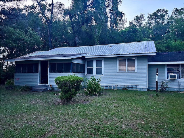 2409 NW 7th St, Ocala, FL 34475 - view of front of property featuring a front yard, a sunroom, entry steps, metal roof, and cooling unit