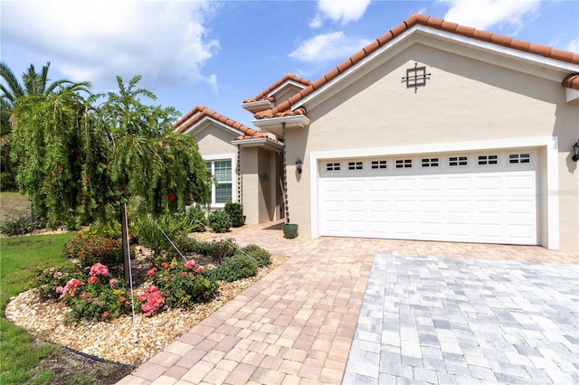 7210 SW 179th Ct, Dunnellon, FL 34432 - mediterranean / spanish house featuring stucco siding, a tile roof, decorative driveway, and a garage