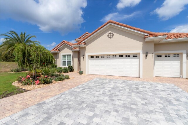 7210 SW 179th Ct, Dunnellon, FL 34432 - mediterranean / spanish home featuring decorative driveway, a garage, stucco siding, and a tile roof