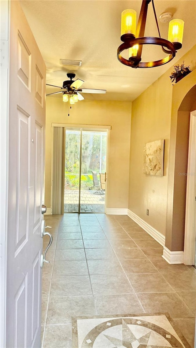 1138 Lumsden Trace Cir, Valrico, FL 33594 - entryway featuring a chandelier, ceiling fan, baseboards, arched walkways, and light tile patterned floors