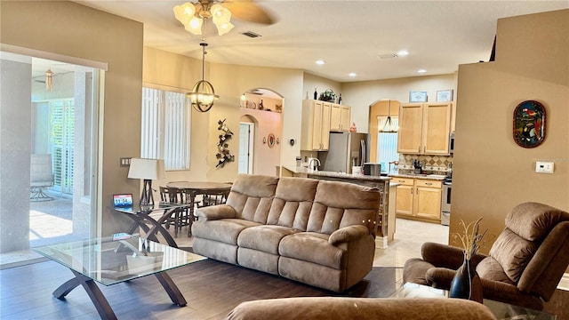 1138 Lumsden Trace Cir, Valrico, FL 33594 - living room featuring a ceiling fan, arched walkways, light wood-style floors, and recessed lighting