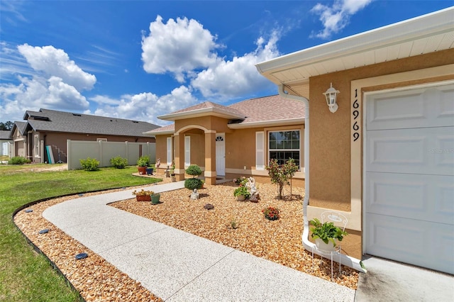 16969 SW 40th Cir, Ocala, FL 34473 - entrance to property featuring stucco siding, a garage, and roof with shingles
