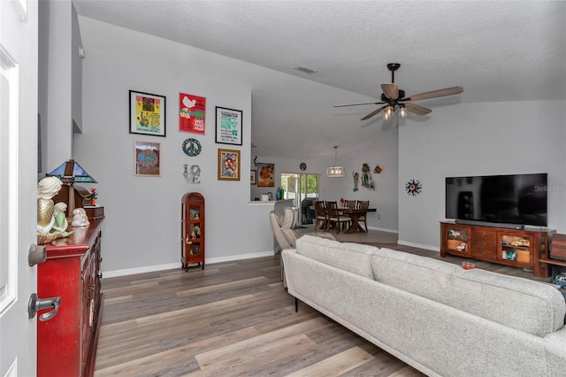16969 SW 40th Cir, Ocala, FL 34473 - living area featuring a ceiling fan, wood finished floors, baseboards, vaulted ceiling, and a textured ceiling