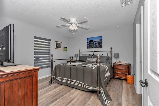 16969 SW 40th Cir, Ocala, FL 34473 - bedroom with light wood finished floors, a textured ceiling, a ceiling fan, and baseboards
