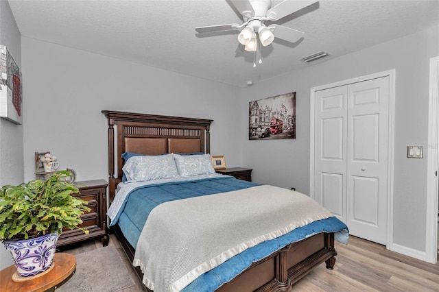 16969 SW 40th Cir, Ocala, FL 34473 - bedroom with light wood-type flooring, a closet, a ceiling fan, and a textured ceiling