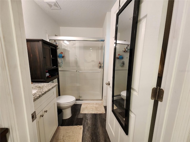 120 Fisher Ct, Ocklawaha, FL 32179 - bathroom featuring toilet, wood finished floors, a shower stall, vanity, and a textured ceiling