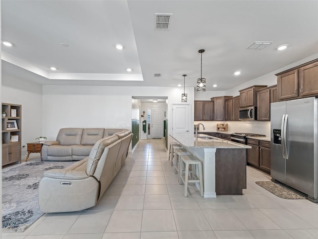 7206 SW 60th Ln, Ocala, FL 34474 - kitchen featuring appliances with stainless steel finishes, a sink, a breakfast bar, light stone countertops, and recessed lighting
