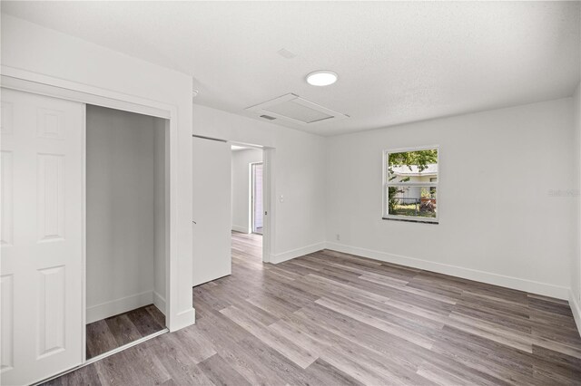 4095 SW 144th St, Ocala, FL 34473 - unfurnished bedroom with attic access, wood finished floors, baseboards, and a closet