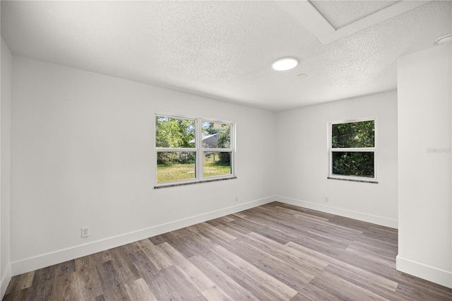 4095 SW 144th St, Ocala, FL 34473 - unfurnished room featuring healthy amount of natural light, a textured ceiling, wood finished floors, and baseboards
