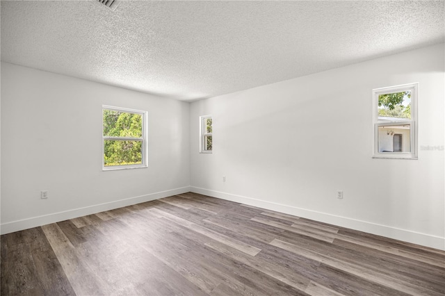 4095 SW 144th St, Ocala, FL 34473 - unfurnished room with a textured ceiling, healthy amount of natural light, dark wood-style floors, and baseboards