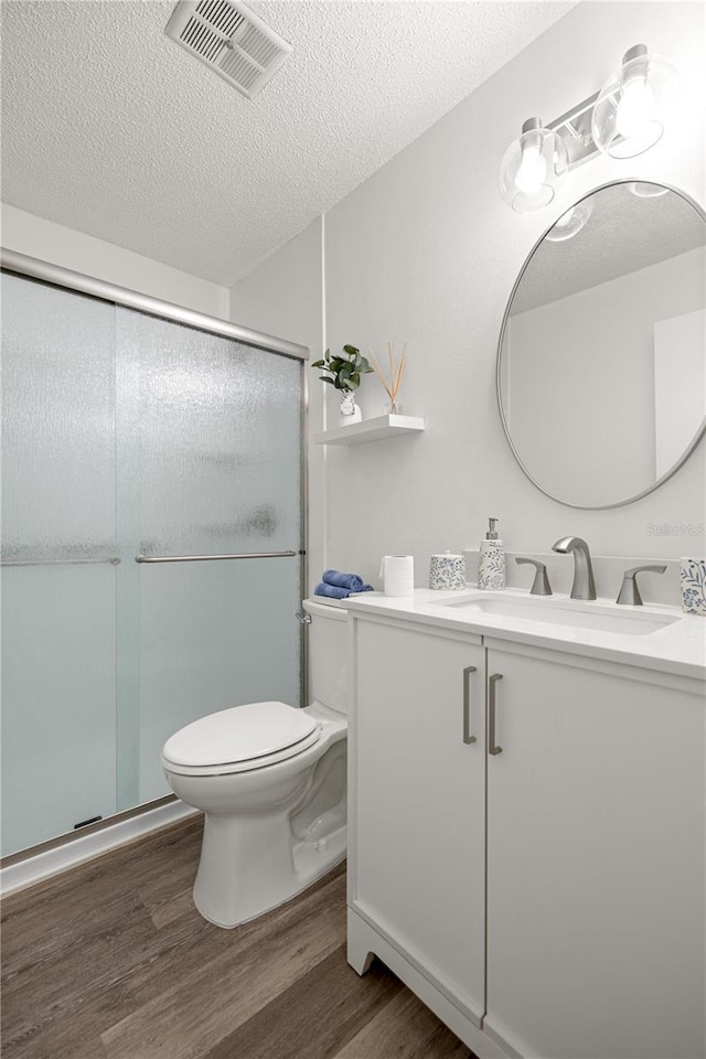 4095 SW 144th St, Ocala, FL 34473 - bathroom with wood finished floors, vanity, toilet, a shower stall, and a textured ceiling
