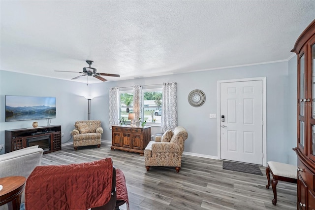 6448 SW 111th Pl, Ocala, FL 34476 - living room with wood finished floors, a textured ceiling, a ceiling fan, baseboards, and ornamental molding